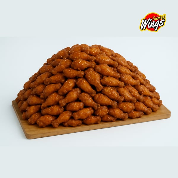 A large mound of golden-brown Twisted Wings, glazed and sprinkled with sesame seeds, on a wooden board.